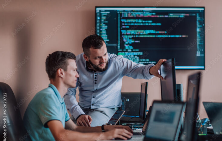 Programmers engrossed in deep collaboration, diligently working together to solve complex problems and develop innovative mobile applications with seamless functionality.