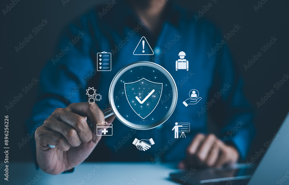 Work Safety and Compliance Concept. Businessman holding magnifying glass with icons work safety, compliance, risk management, and operational efficiency, emphasizing importance of safety standards.